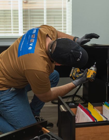 Smoove mover disassembling furniture with a power drill