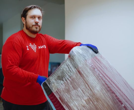 Smoove mover wrapping furniture in protective plastic